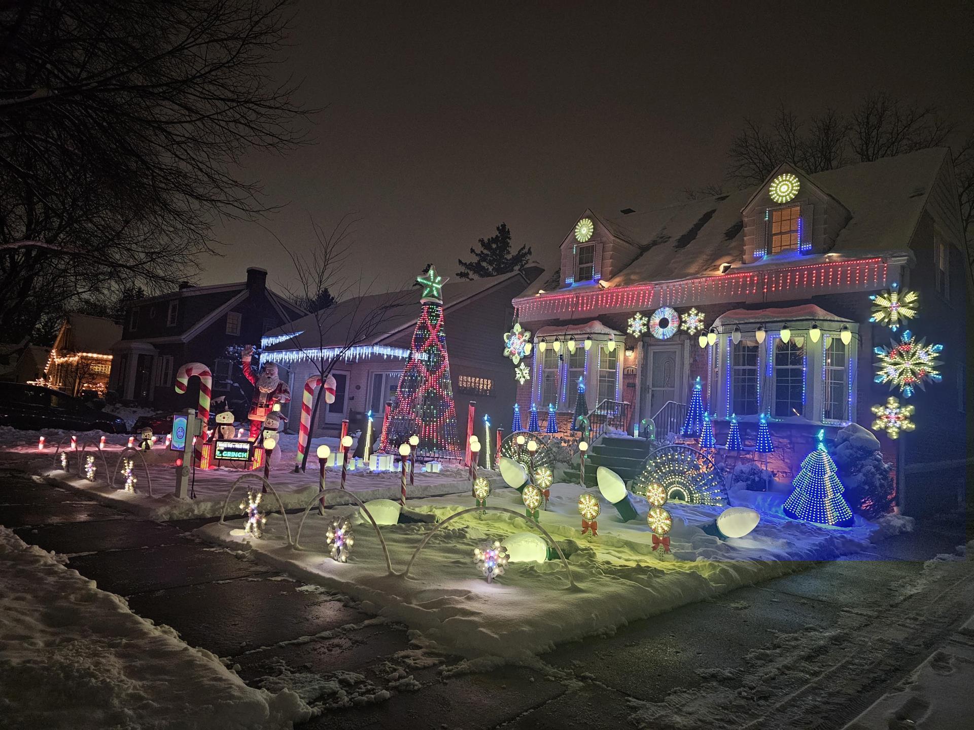 Colorful Christmas lights illuminate a snowy landscape